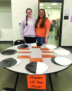 Lamar Science Moon Phases--Josie Pearson (left) and Aimee Pearson, seventh grade science teacher, used their display of the phases of the moon to explain that a solar eclipse can only occur when there is a new moon. --Graphic photo by Stephanie Baker